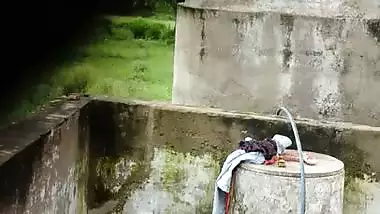 Indian village girl bathing near water tank outdoor